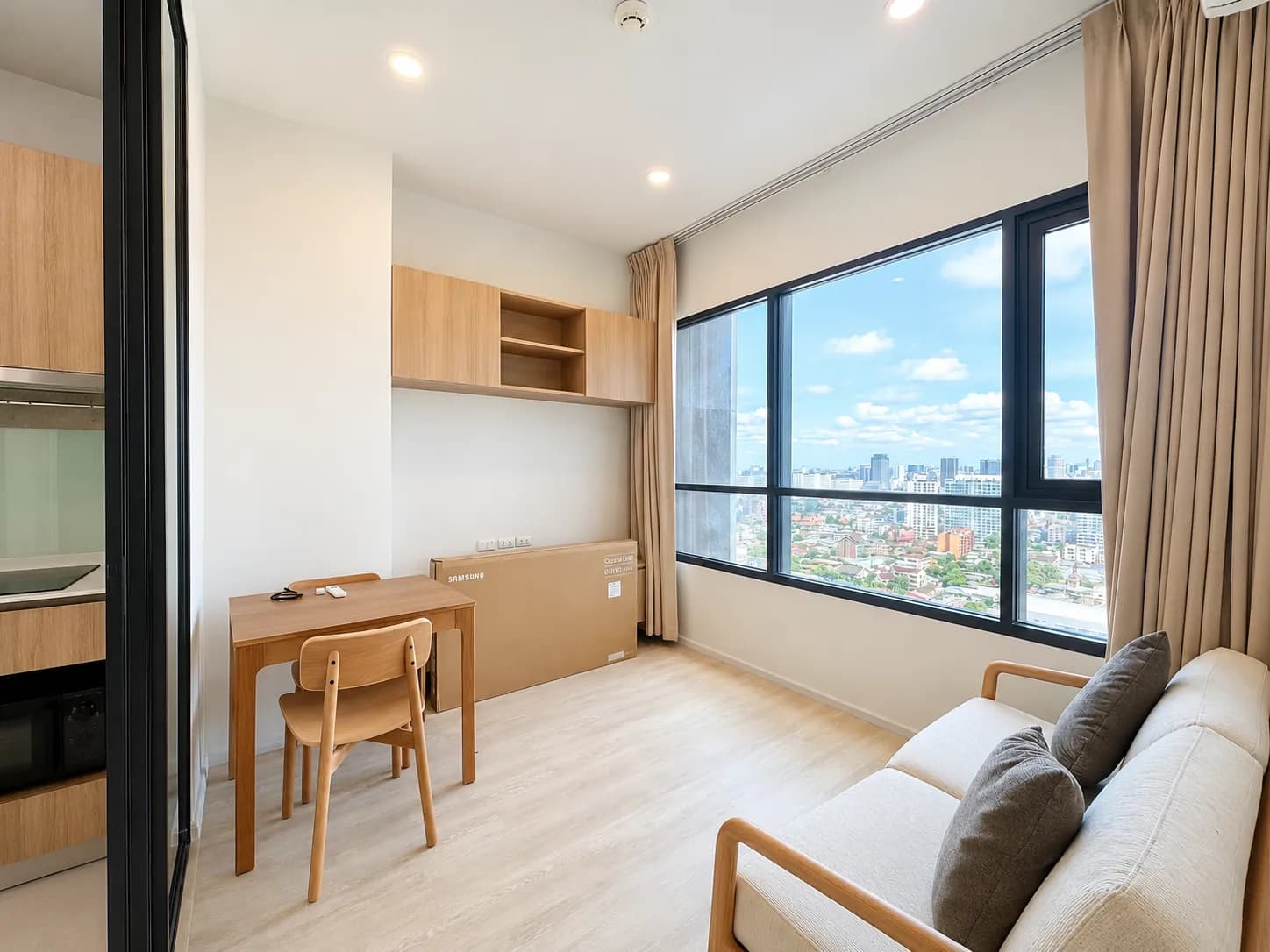 Bright living room and city view in the Knightsbridge Prime Ratchayothin unit
