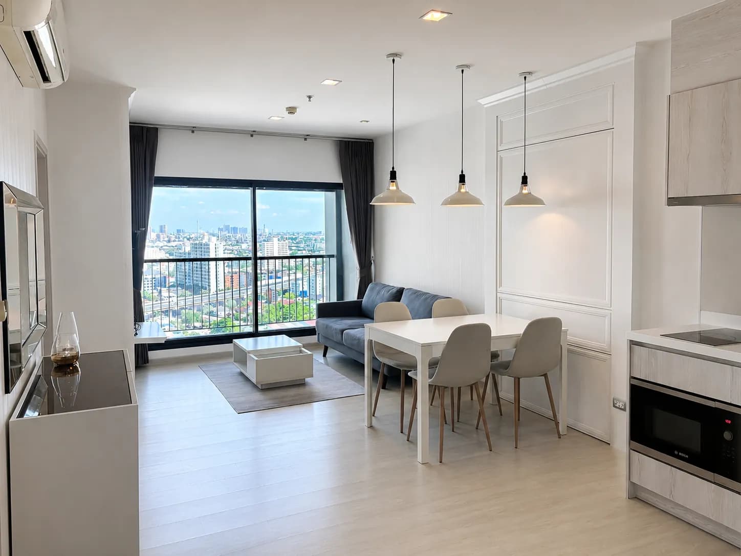 Living and dining area with city view at Life Sukhumvit 48