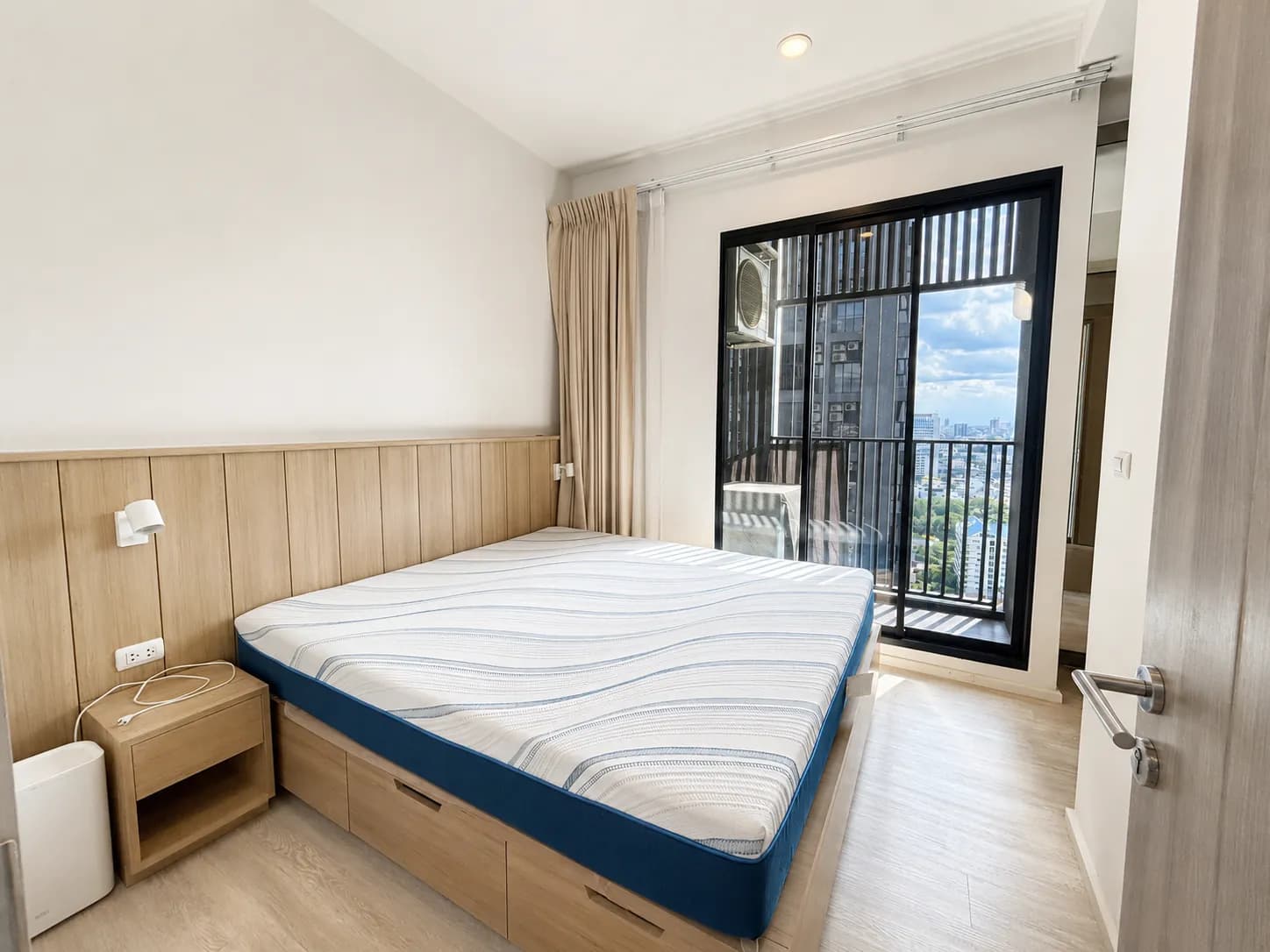 Bedroom with balcony door and natural light in the corner unit