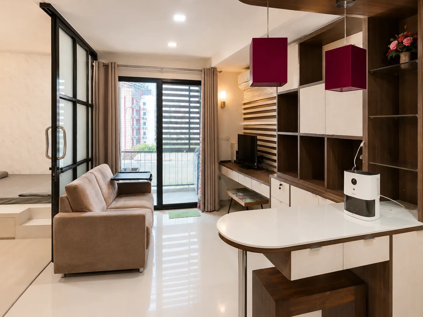 Bright furnished living area with sofa and sliding balcony doors